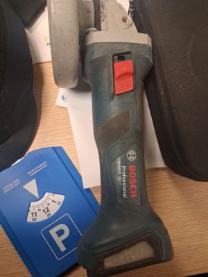 une perceuse sans fil posée sur une table à côté d'une paire de chaussures