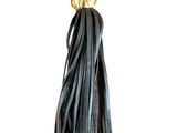 a close up of a black leather tassel with a gold medallion on it