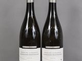 two bottles of wine sitting on top of a table next to each other