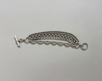 a close up of a silver chain bracelet on a white surface