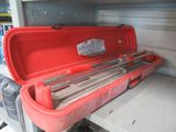 a red tool box with tools in it on a shelf