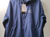 blue jacket hanging on a hanger on a wall with a tag on it