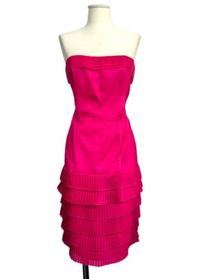 a pink dress on a mannequin stand with a white background
