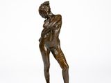 bronze statue of a man holding a tennis racquet on a marble base