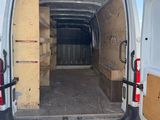 à l'arrière d'une camionnette blanche dont les portes sont ouvertes