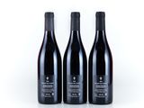three bottles of wine sitting on top of a white surface