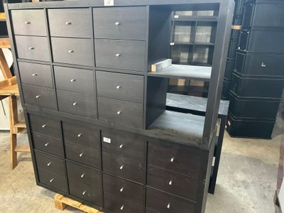 une grande armoire noire à tiroirs dans un entrepôt
