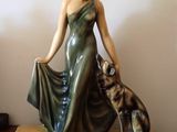 une statue représentant une femme et un chien posée sur une table