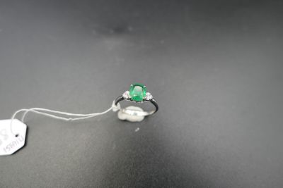 Gros plan sur une bague ornée d'une pierre verte