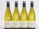 trois bouteilles de vin blanc posées les unes à côté des autres sur une table