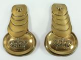 pair of brass candle holders with crowns on them on a white surface