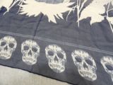 a black and white picture of a bed with a skull and leaves on it
