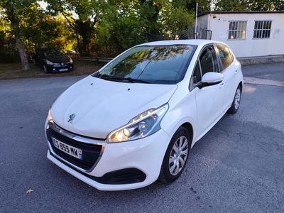 La voiture blanche est garée sur le parking à côté de la maison.