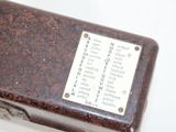 a small brown box with writing on it on a white surface