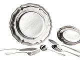 a silver plate and silverware on a white background
