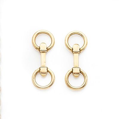 two pairs of gold plated metal earrings on a white background