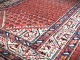 a red and blue rug on the floor in a room