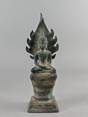 une image représentant une statue de Bouddha assis au sommet d'un vase