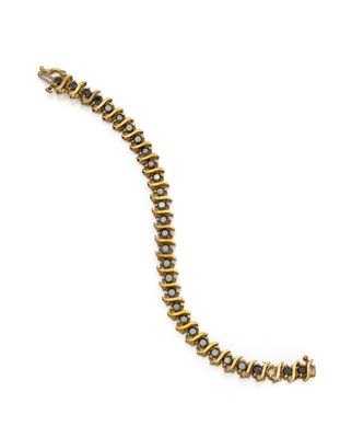 gros plan d'un bracelet en or sur fond blanc