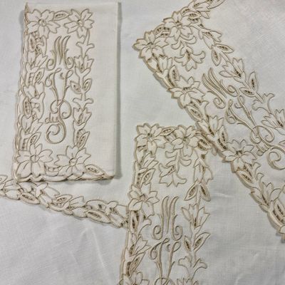 trois broderies sur une nappe blanche, avec une paire de ciseaux et une paire de ciseaux