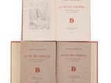 three books sitting on top of each other on a white surface