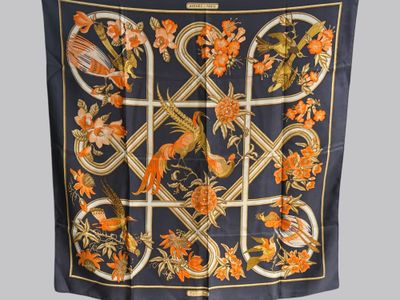 une image représentant un foulard en soie orné de fleurs orange et d'oiseaux