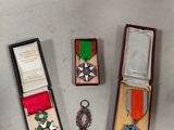 trois médailles et une médaille sont posées côte à côte sur une table
