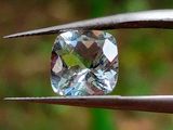 un gros plan d'un diamant tenu par une pince