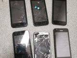 four cell phones are sitting next to each other on a table