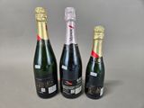 three bottles of champagne sitting next to each other on a table