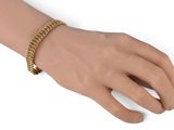 an image of a woman ' s hand with a gold chain bracelet