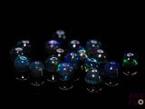 a lot of blue and green glass beads on a black surface