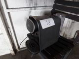 une chaise noire sur laquelle est posée une pancarte, à côté d'une autre chaise noire