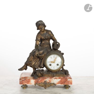une statue de femme assise au sommet d'une horloge