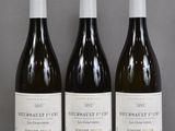 trois bouteilles de vin sont alignées sur une table