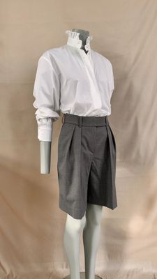 a male mannequin dressed in a white shirt and gray shorts