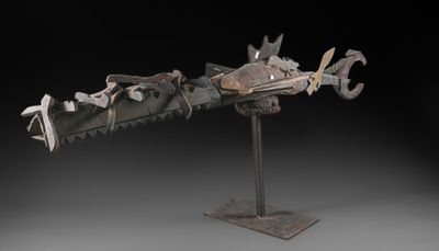 une sculpture représentant un dragon, réalisée en métal et posée sur un socle métallique