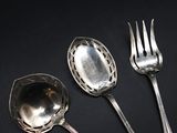 three spoons and a fork on a black surface