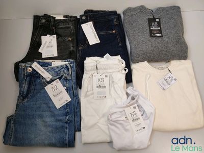 plusieurs paires de jeans sont disposées sur une table
