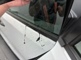 a person holding a cell phone up to the side of a car window