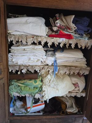 a wooden cabinet filled with lots of clothes and other items