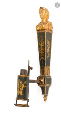 une lampe murale noire et dorée surmontée d'une statue