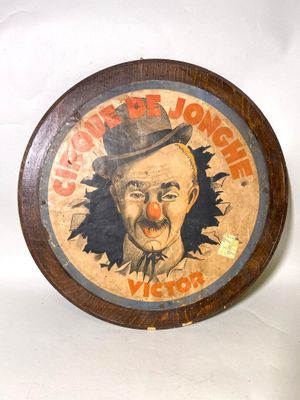 une plaque en bois sur laquelle est peint un visage de clown