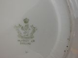 a white plate with a picture of a royal emblem on it