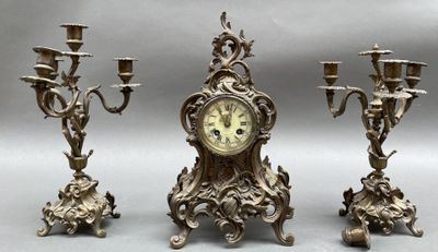 trois bougies et une horloge posées sur une table