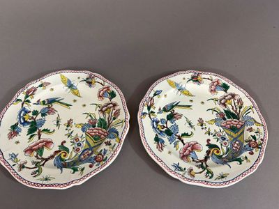 deux assiettes ornées de fleurs et d'oiseaux, posées sur une table