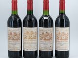 three bottles of red wine sit next to each other on a white surface