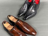 two pairs of brown and black shoes on a gray surface