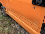 an orange van parked on the side of the road with its door open