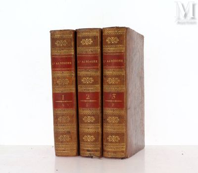 trois livres posés sur une table blanche
